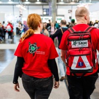 2 Personen vom Awareness Team SAM der Manga Comic Con 2025 laufen durch die Messehalle 2 Personen vom Awareness Team SAM der Manga Comic Con 2025 laufen durch die Messehalle