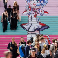 Besucher:innen der Manga Comic Con 2025 vor und auf einer Treppe auf der das Leipziger Messe Maskottchen abgebildet ist Besucher:innen der Manga Comic Con 2025 vor und auf einer Treppe auf der das Leipziger Messe Maskottchen abgebildet ist
