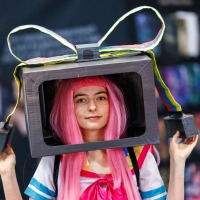 Cosplayer:in mit pinker Perücke und Schleifen-Box auf dem Kopf auf der Manga Comic Con 2025 Cosplayer:in mit pinker Perücke und Schleifen-Box auf dem Kopf auf der Manga Comic Con 2025