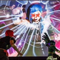 Zwei Cosplayer:innen vor einer großen Leinwand mit einem Manga-Charakter auf der Manga Comic Con 2025 Zwei Cosplayer:innen vor einer großen Leinwand mit einem Manga-Charakter auf der Manga Comic Con 2025