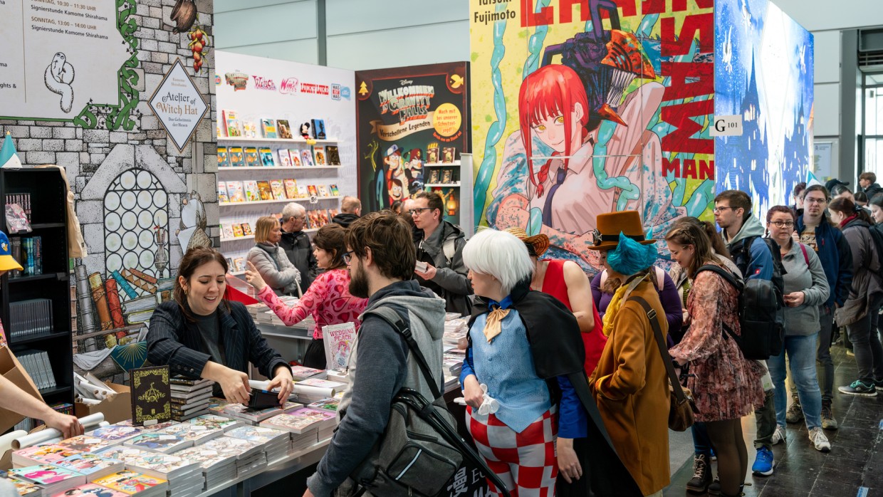 Besucher:innen stehen Schlange an einem Messestand auf der Manga-Comic-Con 2025 Besucher:innen stehen Schlange an einem Messestand auf der Manga-Comic-Con 2025