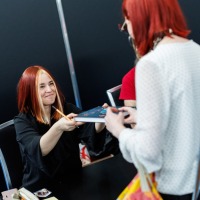 Jenny Jinya überreicht einem Fan ein signiertes Buch auf der Manga-Comic-Con 2025 Jenny Jinya überreicht einem Fan ein signiertes Buch auf der Manga-Comic-Con 2025